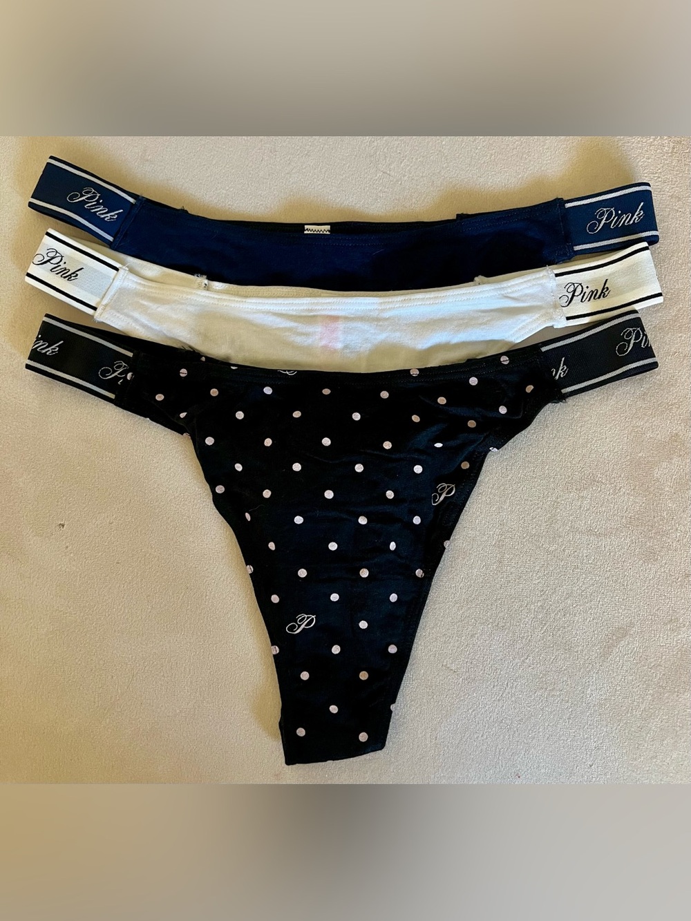 3 NWT Victoria’s Secret thong panties.  Black, white, navy blue, size medium